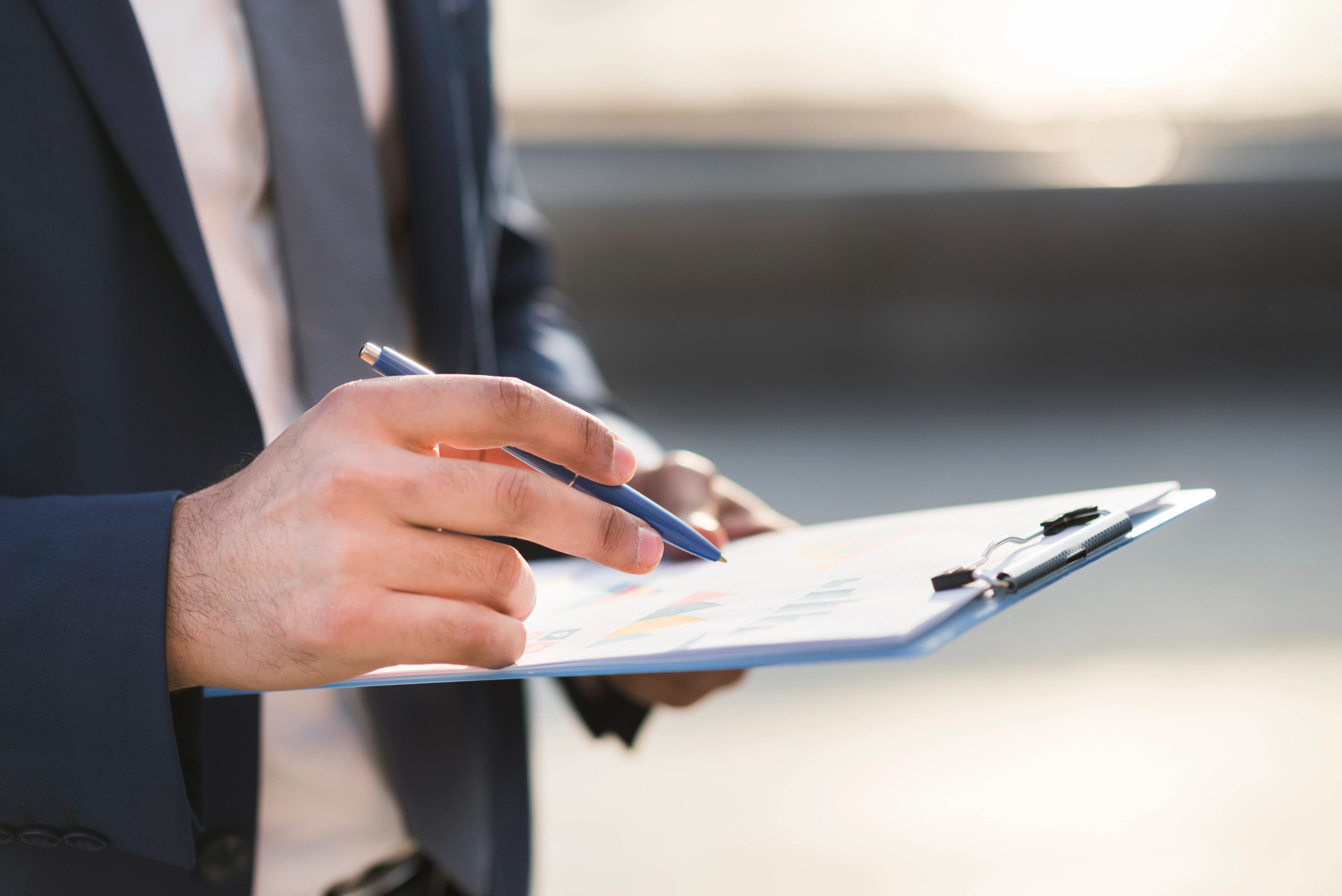 Close up business man checking clipboard
