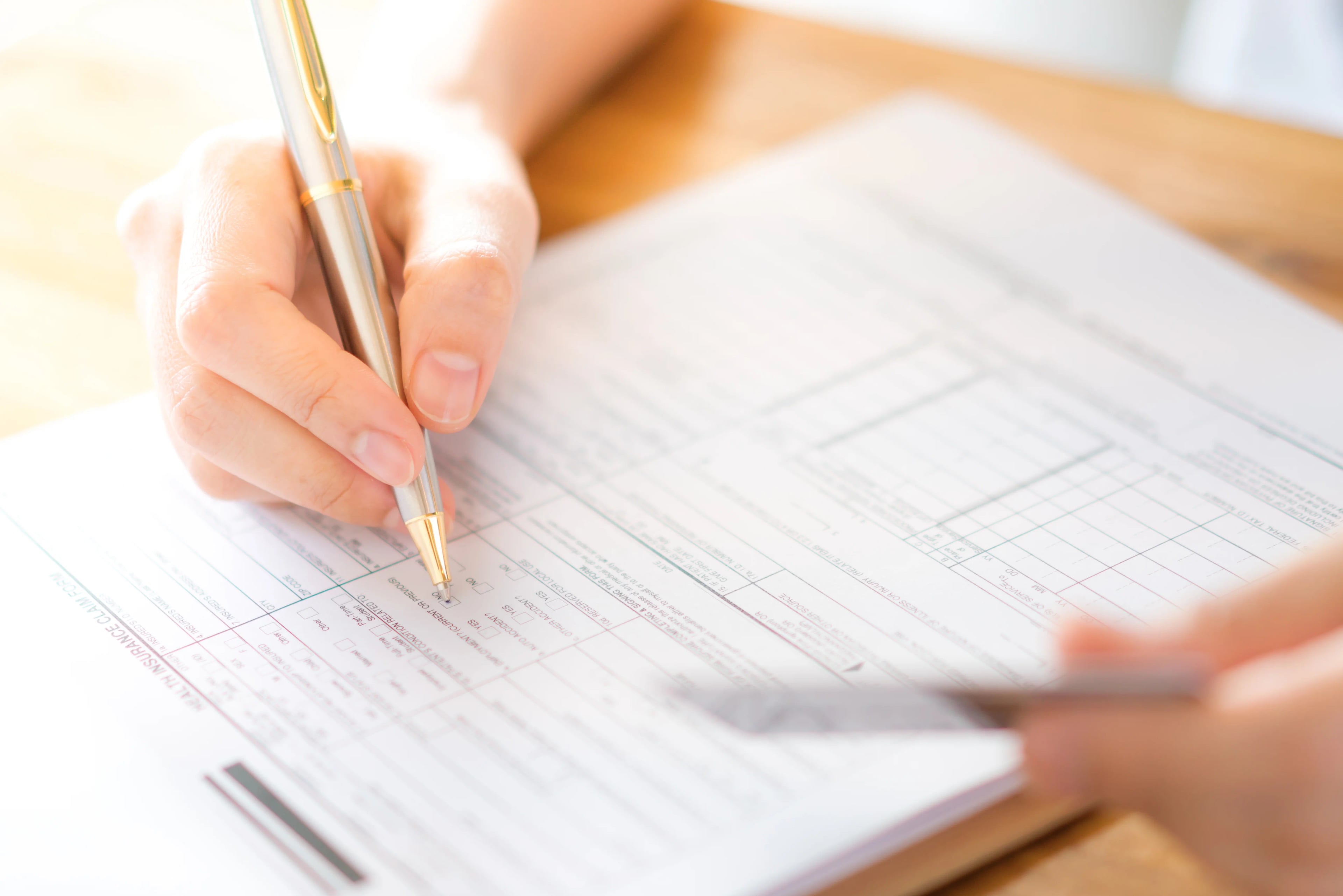 Hand with pen credit card application form